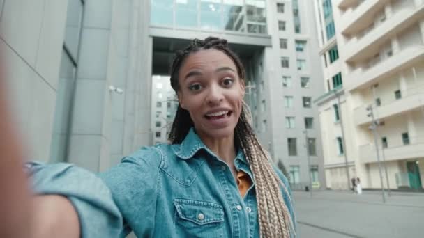 Video Call Portrait einer schönen jungen stilvollen Afroamerikanerin mit Dreadlocks in Freizeitkleidung, die mit Freunden oder Kollegen spricht, während sie draußen auf der City Street steht. Winkende Hand in der Stadt — Stockvideo