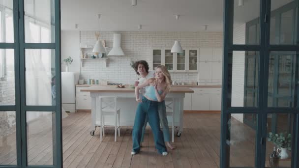 Gelukkig funky jong romantisch koppel dansen in de keuken. jong schattig blond en krullend guy having plezier — Stockvideo