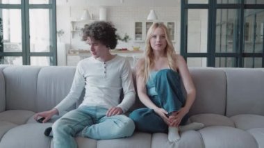 Milenyum sarışın kız ve hippi çocuk evdeki kanepede otururken mutlu bir futbol takımı zaferi, aşırı neşeli heteroseksüel arkadaşlar çığlık atıyor heyecanlı yüz ifadeleri, spor futbolu.