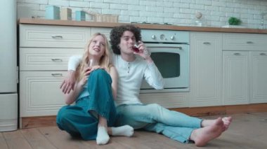 Genç, mutlu, evli bir çift yerde oturuyor. Bardakları şarapla tokuşturmak, yeni ev alımını kutlamak, başarılı mortgage yatırımları. Aile eşi flört etmekten zevk alıyor. Birlikte bir dairede vakit geçirin.