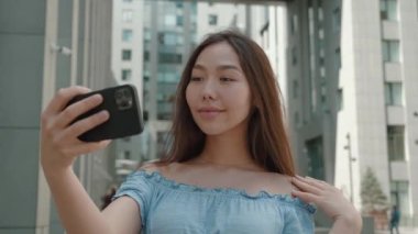 Mutlu Asyalı kız şehir geçmişinin özçekimini yapıyor.