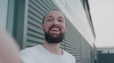 Şehir Caddesinde dikilirken arkadaşlarıyla ya da iş arkadaşlarıyla konuşan şık giyinen genç ve güzel bir hippinin portresi. Kentsel Çevrede Dalgalanan El.