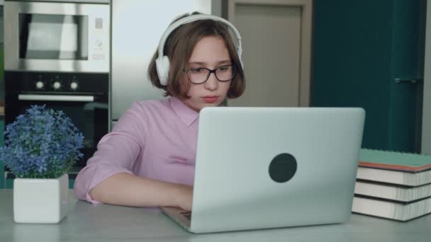 Concept van online leren. het kind wordt ingeschreven in een online school. meisje met laptop huiswerk doen. 4k, slow-motion — Stockvideo
