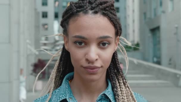 Retrato de bela mulher afro-americana elegante com dreadlocks sorrindo para a câmera com confiança na cidade, vestindo em uma jaqueta de ganga, Close Up Shot — Vídeo de Stock