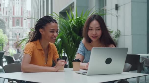 Dos hermosas chicas con portátil feliz lo que ven en la pantalla y chismes — Vídeo de stock