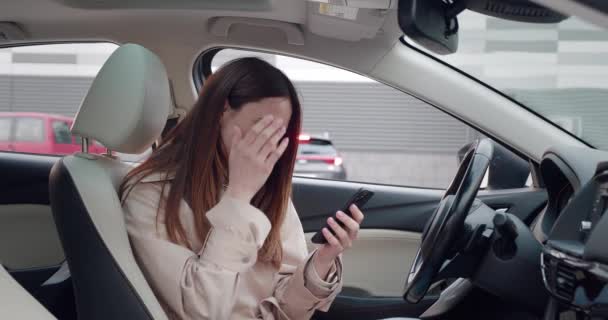 Frau sitzt mit Smartphone im Auto Geschäftsfrau checkt Mails, Chats, während sie Nachrichten liest. — Stockvideo