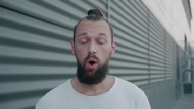 Şaşırmış Avrupalı adam, vay canına diyor. Güzel saç stili olan yakışıklı adam park alanının yakınındaki kameraya şaşırdı..