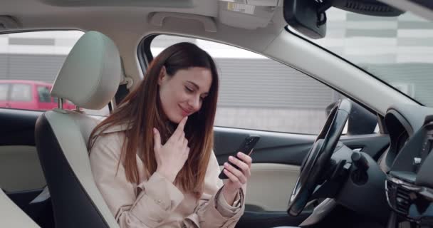 Retrato de mujer joven usando su Smartphone en el coche. Empresaria está revisando correos, chats mientras, sirviendo noticias. — Vídeos de Stock