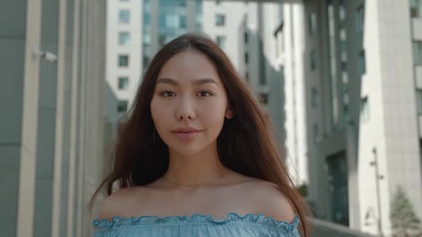 Nahaufnahme Porträt asiatische junge Frau in mit nackten Schultern Outfit Blick in die Kamera draußen auf der Straße fühlen sich glücklich. Millennial Porträt niedlich weiblich schön modern lady hübsch Zeitlupe urban city — Stockvideo