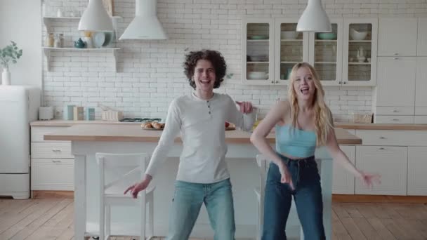Feliz funky jovem casal romântico dançando pulando na cozinha — Vídeo de Stock
