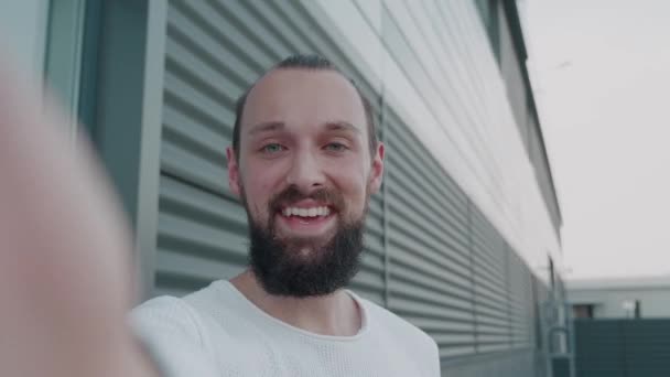 Hipster masculino en ropa casual inteligente hablando con amigos o colegas mientras está parado afuera en City Street. Mano de Ola en Ambiente Urbano. — Vídeos de Stock