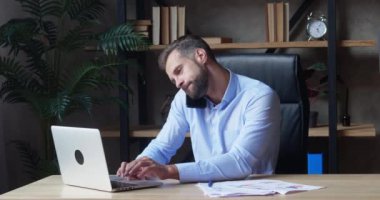 İşadamı dizüstü bilgisayar kullanıyor ve akıllı telefonu aynı anda arıyor. İş kurma ofisinde fazla mesai yapıyor. Çok görevli çalışan, mali istatistikleri incelemekle meşgul, aşırı çalışma, arama