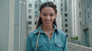 Sokakta duran Afro-Amerikan yenilikçi kadın portresi. Kameraya bakıyor ve gülümsüyor. Siyah stil. Dreadlock 'lar. Afro Saç Tarzı.