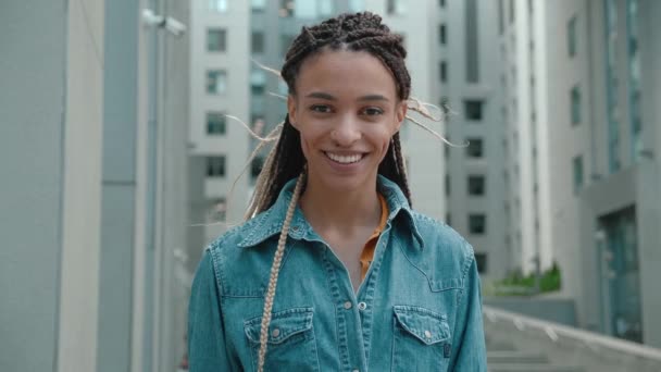 Portret van een stijlvolle Afro-Amerikaanse hipster op de achtergrond. Ze keek naar de camera en glimlachte. Zwart Stijlvol. Dreadlocks. Afro kapsel. — Stockvideo