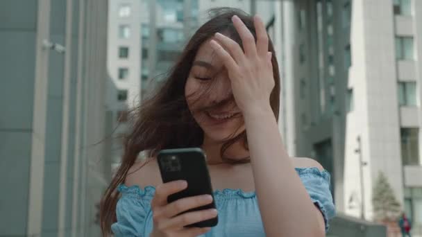 Close up young asian woman with spartphone in outdoor. Concept modern tehnology.Female reading good news or message and smilling — Stock Video