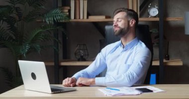 Gülümseyen iş adamı video konferansında el sallıyor. Çatı katındaki modern ofiste video görüşmesi yapan yakışıklı bir adam.