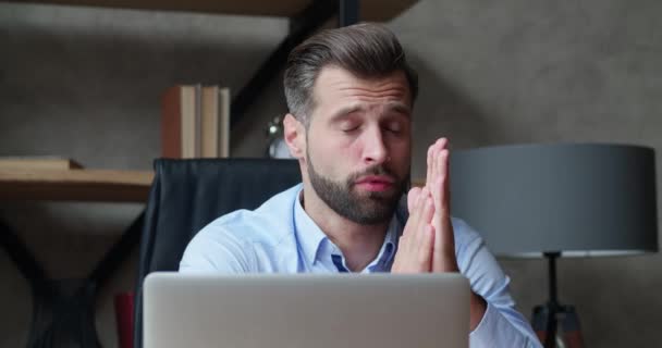 Vista frontal de um empresário caucasiano cansado trabalhando em um escritório moderno, sentado em uma mesa olhando para a tela do computador, esfregando os olhos. Distanciamento social — Vídeo de Stock