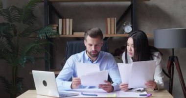 Neşeli iş adamları ve partneri dizüstü bilgisayara bakıp evrak atarken eğleniyorlar.