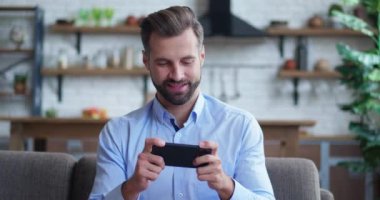 Erkek milenyum profesyoneli elinde akıllı telefon, mobil oyun oynuyor. Kazanan konsept İyi haber