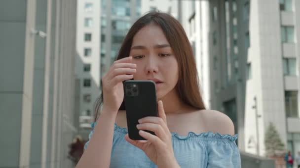 Shocked frustrated asian woman student feel stressed look at smartphone screen worried of problem read bad online news receive failed exam results concept standing in outdoor — Stock Video