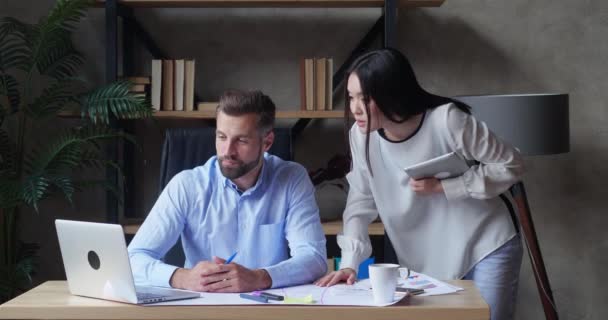 Dos socios de negocios exitosos felices discutiendo la estrategia de desarrollo de la empresa mirando en el ordenador portátil en una reunión de lluvia de ideas en la oficina. Socios sonrientes negociando los resultados de la investigación — Vídeos de Stock