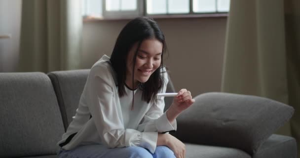Mulher asiática feliz Sentindo-se feliz depois de verificar o teste de gravidez com resultado positivo — Vídeo de Stock