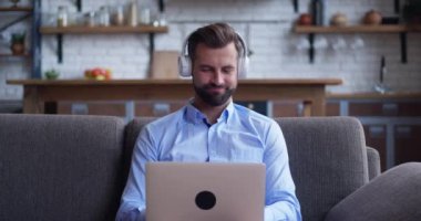 Gülümseyen genç adam vlogger, kamera konuşmasına bak, canlı video konferansı yap, blog blogu kaydet, modern iç plan koltuğuna otur.