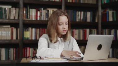 Mutlu kız öğrenci uzaklık öğrenimi, sanal sınıfta öğretmenle video konferans görüşmesiyle online çalışma, ev kütüphanesinde dizüstü bilgisayardan televizyon dersi izleme,.