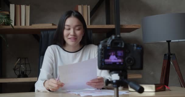 Asian woman with camera recording video at modern office. Business coach writes a course for a beginner startup — Stock Video