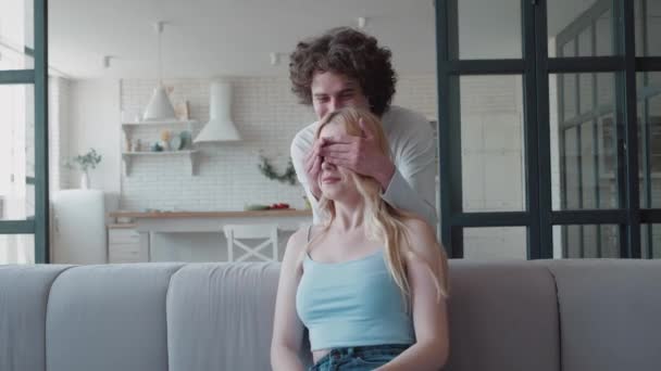 Guy becsukja a lány szemét a kezét, és megöleli őt szórakozás érzés szeretet és gyengédség. Emberi érzelmek és érzések, emberek és kapcsolatok fogalma. — Stock videók