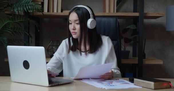 Szczęśliwa azjatycka dziewczyna ze słuchawkami studentka korzystająca z laptopa komputer oglądanie odległość nauka seminarium klasy, zdalne webinarium uniwersyteckie lub o wirtualnej klasy spotkanie, studia online w — Wideo stockowe