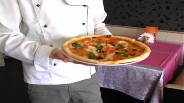 Şef pizza teslim eder.