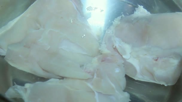 水の中に鶏肉を投げる。骨なしチキンを鍋を準備します。 — ストック動画