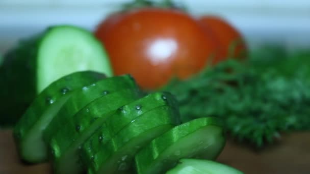 Haciendo una ensalada. Corta un pepino. Un tomate . — Vídeo de stock