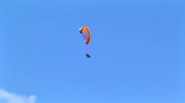 Bir yaz günü dağların ve vadilerin üzerinden uçan paraglider. Alpler ve Salzkammergut tepelerinin ve gölün muhteşem manzarası. Mavi gökyüzü ile nefes kesen vahşi bir doğanın üzerinde paraşütle atlıyor..