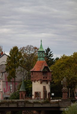 Freiburg im Breisgau, Almanya - 11 01 2012: Köprüdeki küçük ortaçağ kulesi. Bulutlu sonbahar gününde Boş Avrupa caddesi