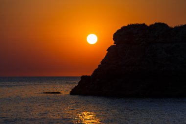 Kayalık sahilde gün batımı