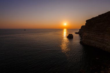 Kayalık sahilde gün batımı
