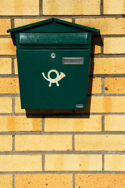 green mailbox on the brick wall
