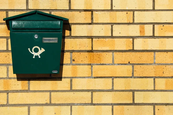green mailbox on the brick wall
