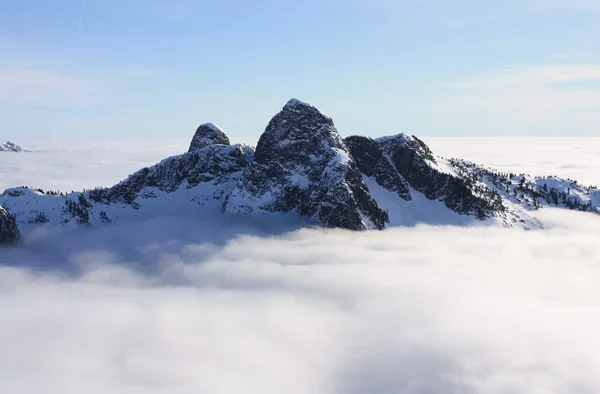 The Lions above the clouds in North Shore Mountains, BC, Canada. — Stock Photo, Image