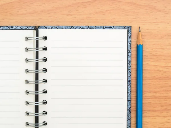 Top vista caderno vazio e lápis azul — Fotografia de Stock