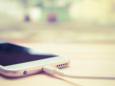 Ahşap masa üstünde batarya şarj Smartphone