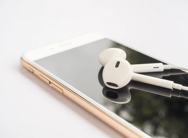 Earbuds on top of smartphone screen isolate — Stock Photo, Image