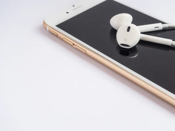 Apple earPods on top of Apple iPhone — стоковое фото