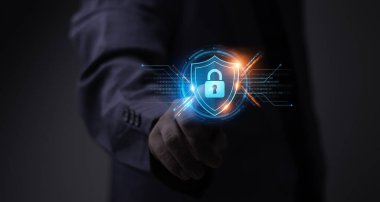 İş adamı Siber Savunma kalkanını çalıştırıyor. Siber güvenlik hologramı Ağ Güvenliğini, Güvenlik Duvarını ve Veri Şifrelemesini gösteriyor.