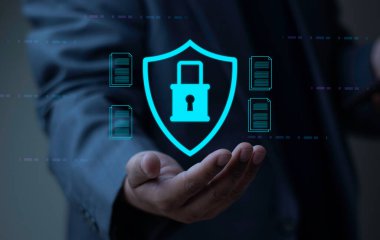 Siber Güvenlik Veri Koruma. Dijital kalkan ve asma kilit taşıyan bir işadamı belgeleri güvenceye alıyor.