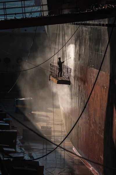 Potencia de los trabajadores del astillero lavando un barco en dique seco . — Foto de Stock