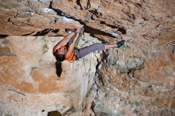 Girl climber climbs on rock. — Stock Photo, Image