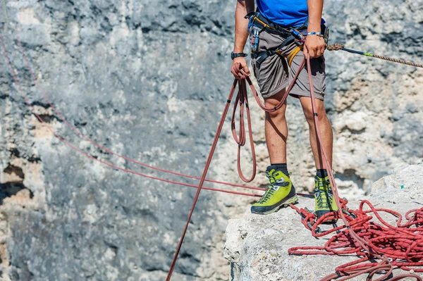 Human legs on cliff with rope. — Stock Photo, Image